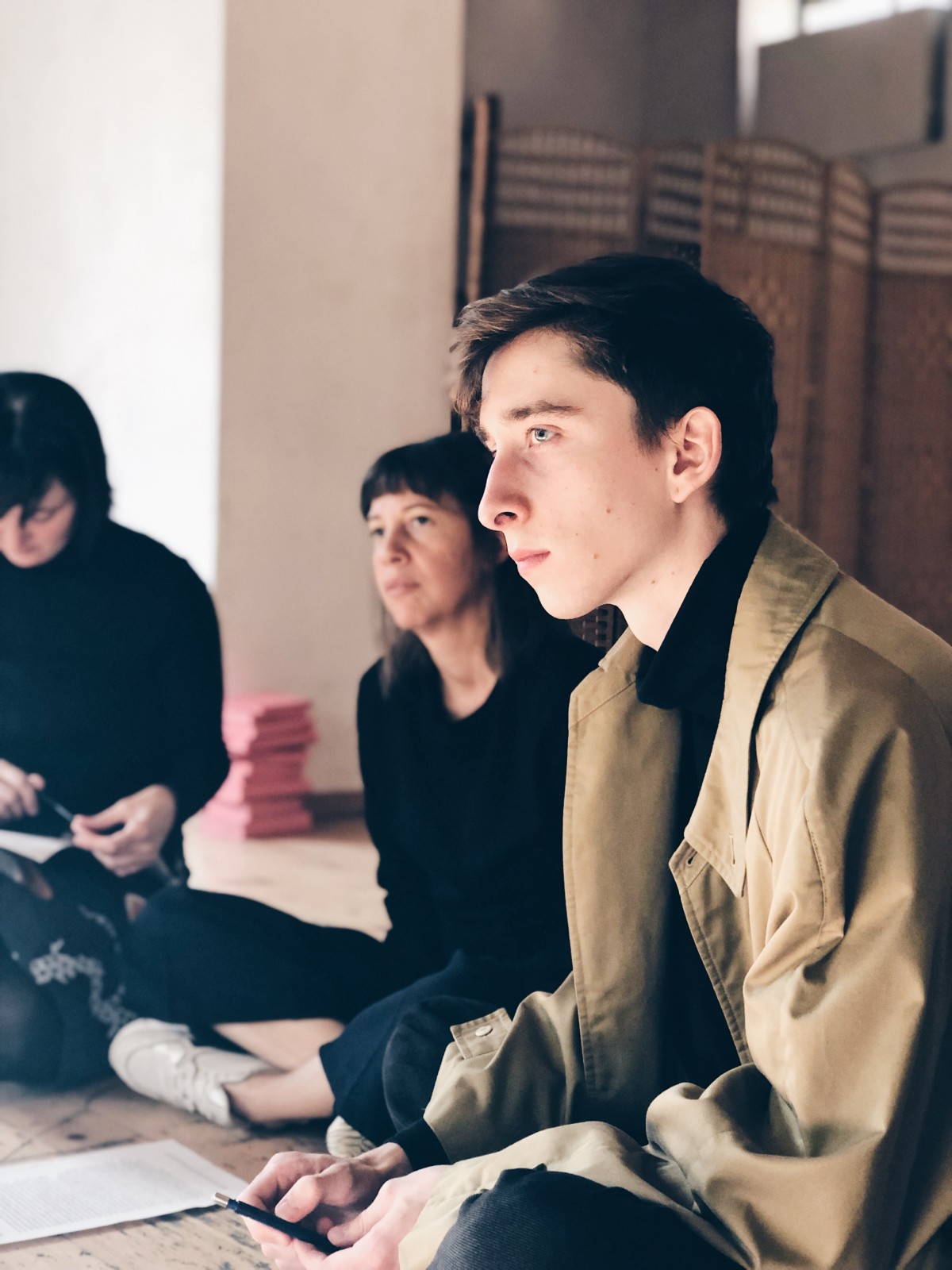 Studiernde sitzen am Boden und hören zu.