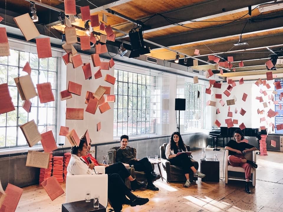 Fünf Menschen sitzen in einer Sesselrunde und unterhalten sich. Die Location ist das Brick-5